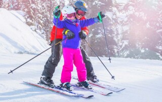 Child learns to ski with parent
