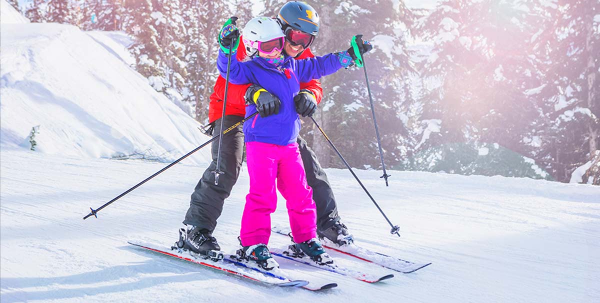 Child learns to ski with parent